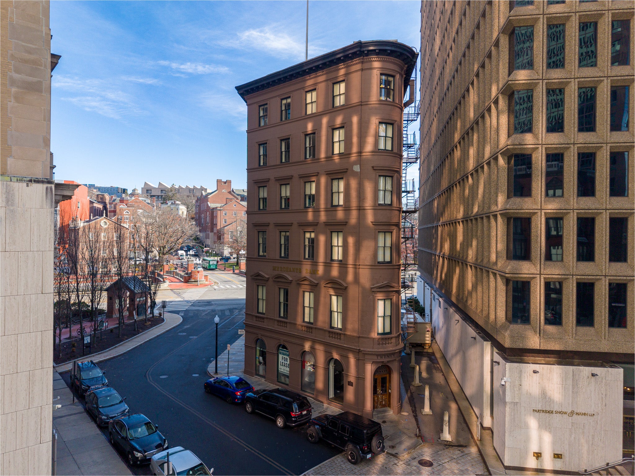 Tall brown building in an urban setting with clear blue sky