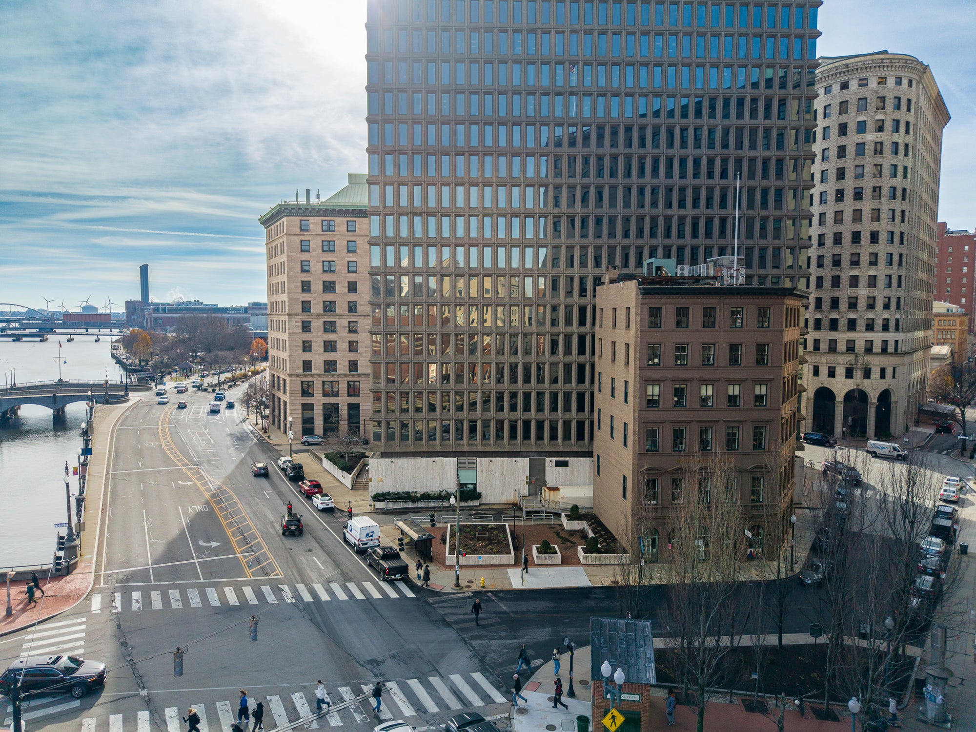 City street with tall buildings and a river in the background