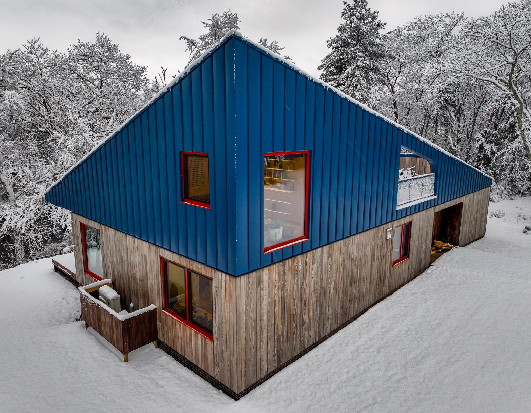 Blue and wooden cabin in a snowy landscape
